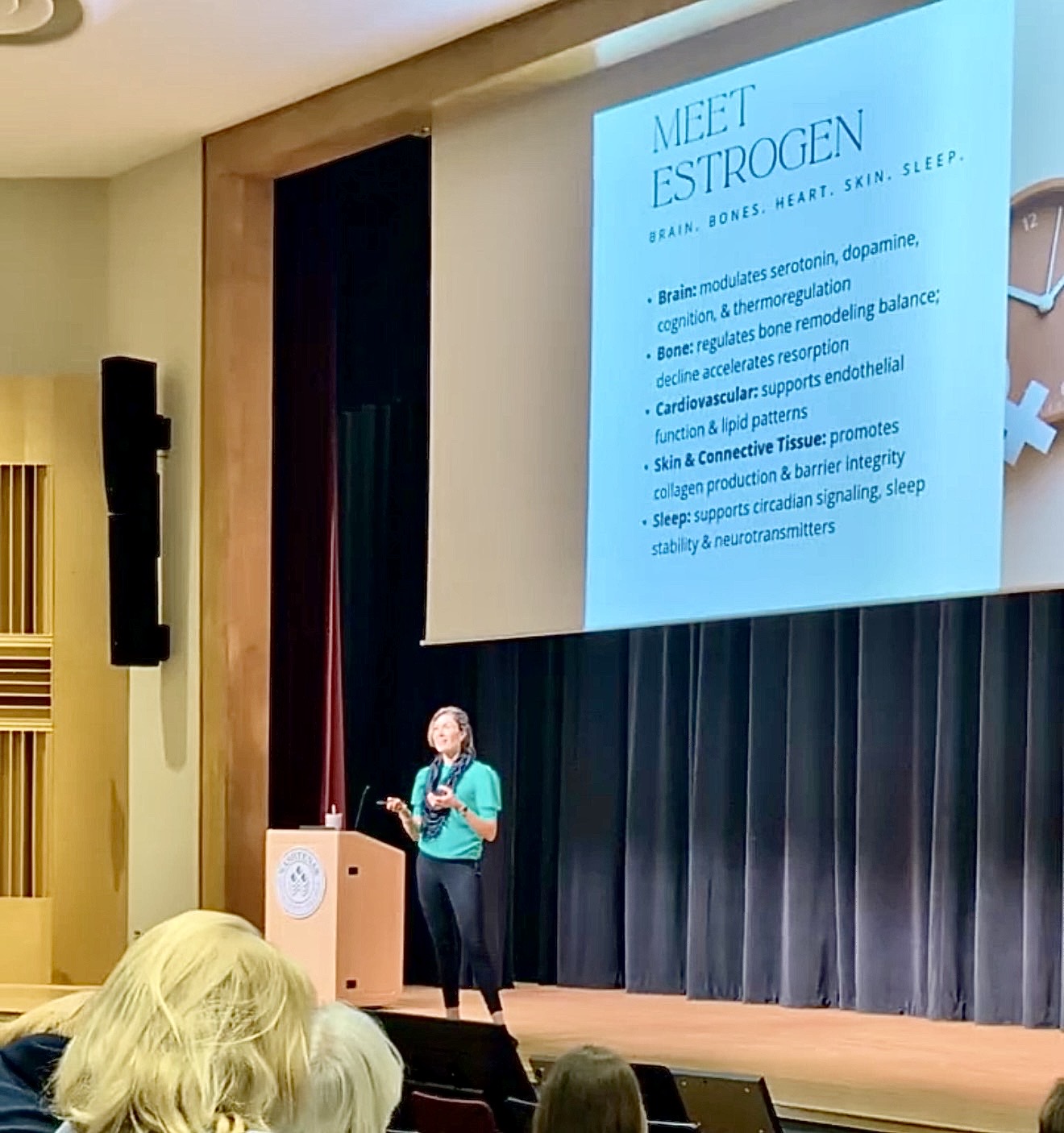 Jessica Corwin speaking on stage about estrogen and midlife health